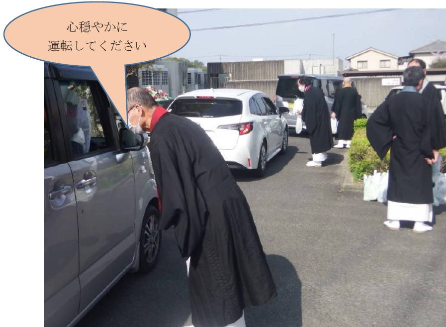 お坊さんが交通安全グッズを配布する写真