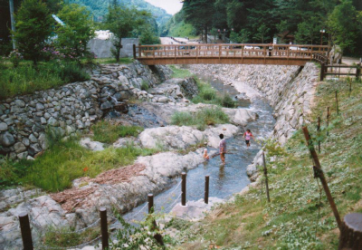 キャンプ場沿いの川で遊ぶ子供達の写真