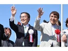知事が安藤さんと笑顔で手を振っている