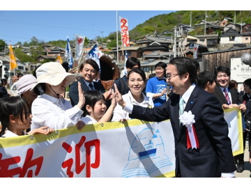 知事が島民と手をタッチしている