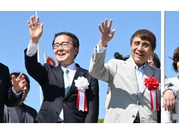 知事と安藤さんが笑顔で手を振っている